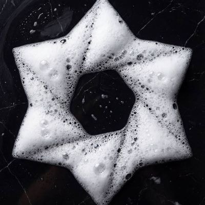 Ultra-realistic top-down photograph of detergent foam forming a precise [subject