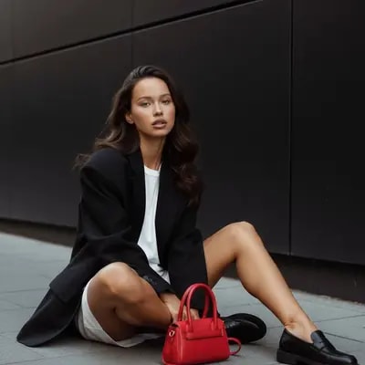 street portrait, editorial fashion, red bag accent, black wall backgro