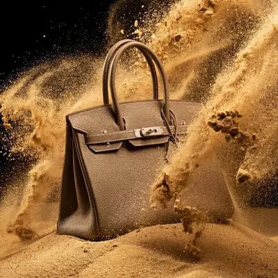 [YOUR PRODUCT] placed on a small dune of fine, dry sand. The product i